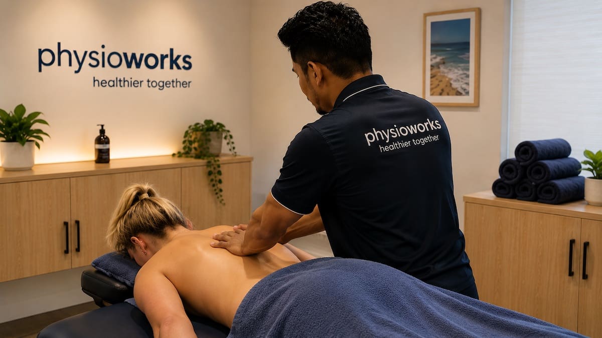 Massage therapist providing upper back treatment in a modern PhysioWorks Sandgate clinic room.
