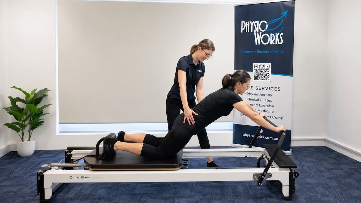 Pilates for back pain with physiotherapist guiding trunk control on reformer
