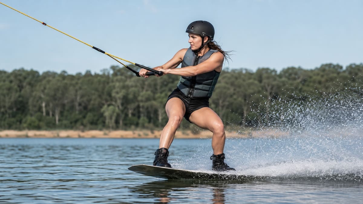 Wakeboarder landing with flexed knees during water skiing and wakeboarding